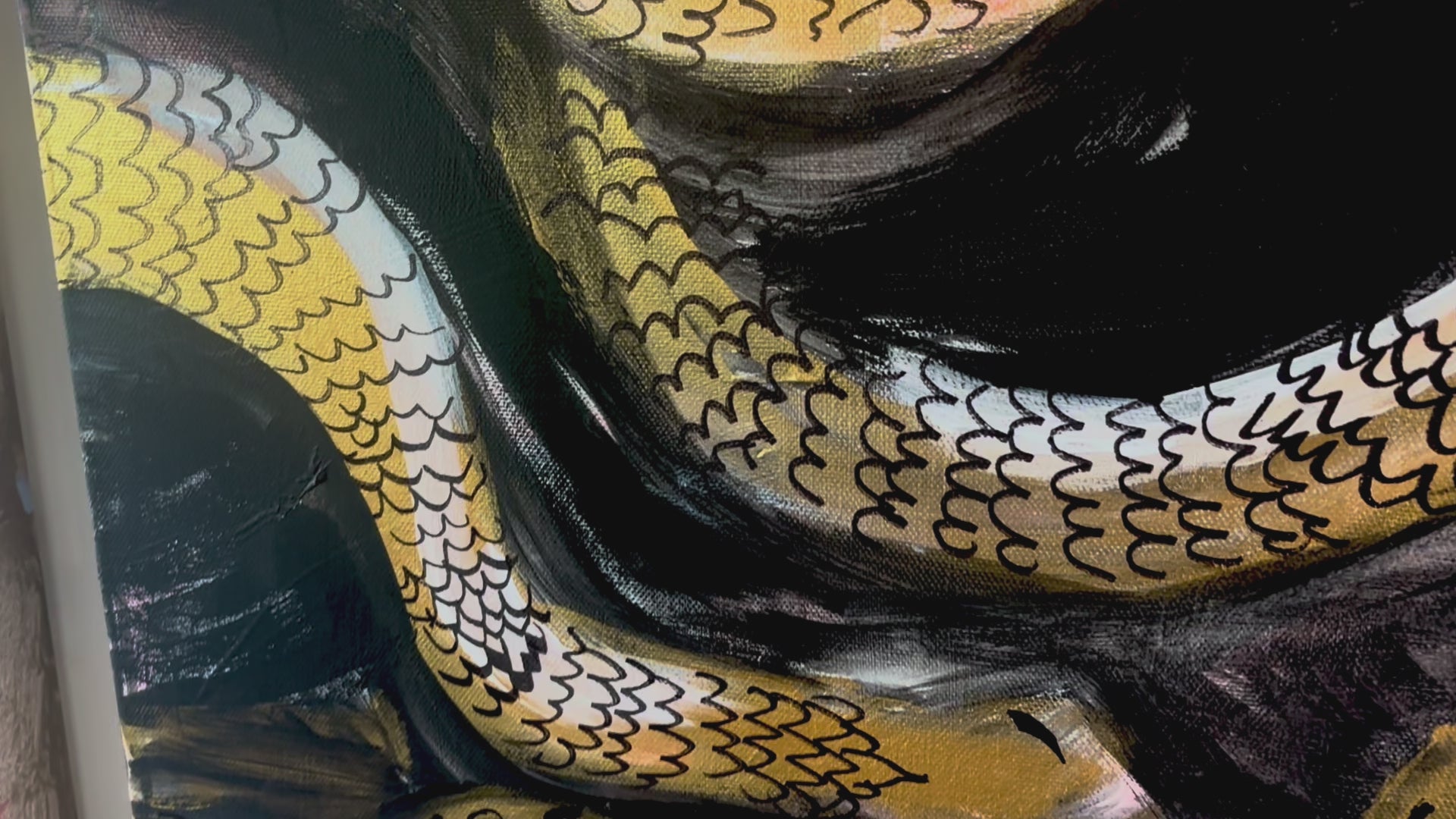 A closeup video of the "Medusa” painting, the painting depicts golden snakes winding around each other and around the feminine face