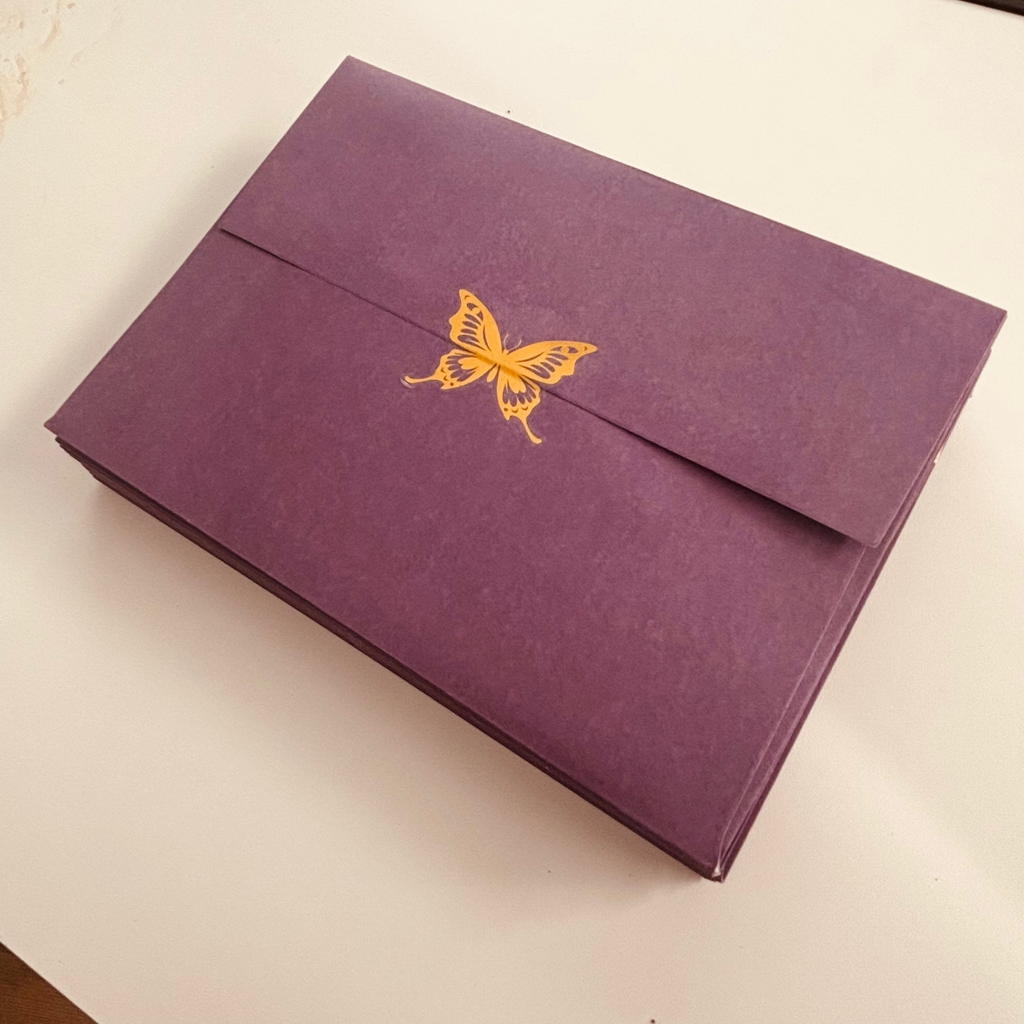 Dark purple envelope with a Golden butterfly sticker to seal. 